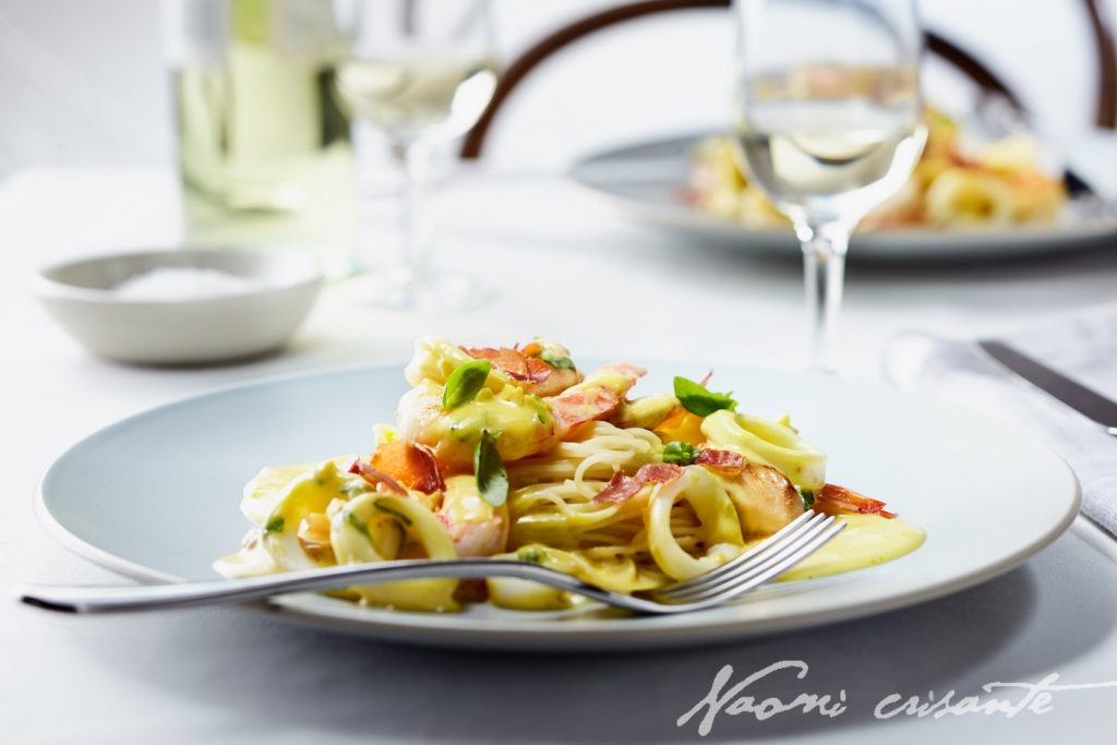 Seared seafood, basil saffron cream, prosciutto flakes on angelhair pasta